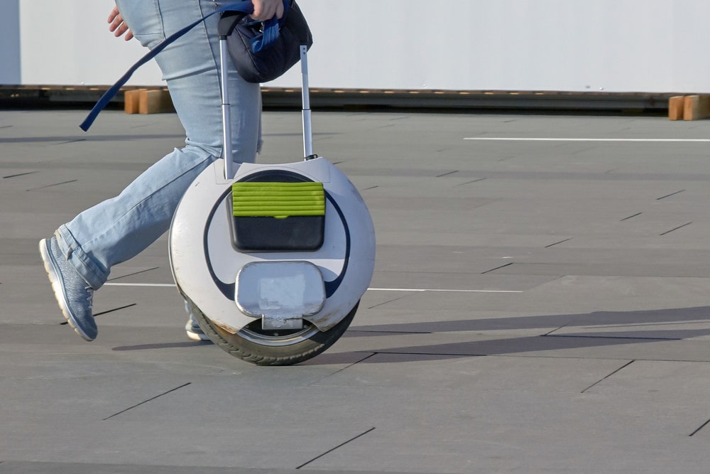 A rider walking his Electric Unicycle, Proper Electric Unicycle Battery Care, Maintenance, and Charging will ensure long battery life.